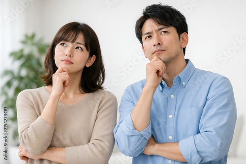 Plakat 腕を組みながら真剣な表情で悩み事を相談し考え込むカジュアルな服装の若い男女のペア