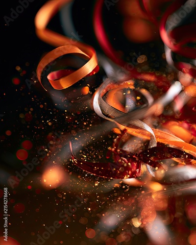 Festive, swirling ribbons with sparkling, blurred light particles and bokeh effects
