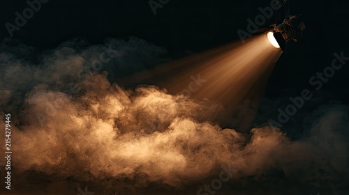 A single spotlight illuminates dense, swirling clouds of golden smoke on a dark stage