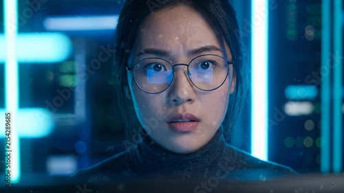 Asian female youth experiencing curiosity and concern, young adult focused computer screen, digital interface, technology, glowing blue data, intense concentration, surprise, wide eyes, futuristic
