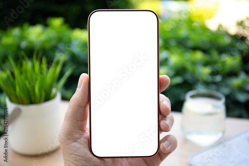 Man hand holding phone blank white screen mockup office desk