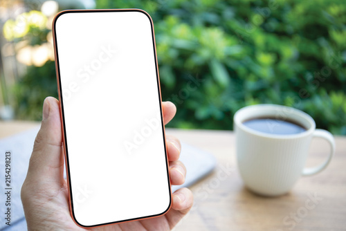 Man hand holding phone blank white screen mockup office desk