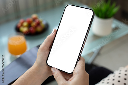 woman hand holding phone blank white screen mockup cafe desk