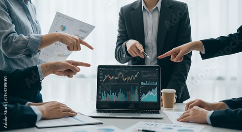 Professional team analyzes financial graphs during business meeting.