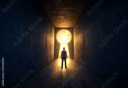 Silhouette of a person standing in a dark tunnel with a bright keyhole light ahead symbolizing hope