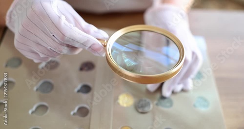 A collector examines unique coins using a magnifying glass in a warm and inviting room filled with coin albums. Each detail reveals a story of history and value.