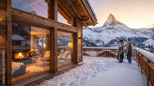A cozy wooden ski chalet in the Swiss Alps surrounded by pristine white snow at sunset. A happy young couple relaxes on a heated balcony, sipping warm sweet hot chocolate.