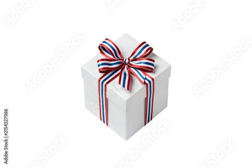 A pristine white gift box with a vibrant red white and blue striped ribbon on a black background