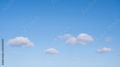 Obraz na plátne Calm and clear light blue sky adorned with several small, isolated fluffy white cumulus clouds, minimalist and tranquil