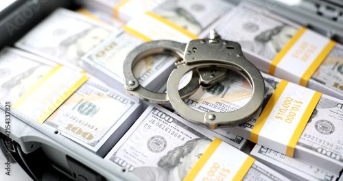 A striking display features stacks of cash alongside shiny handcuffs, highlighting the tension between wealth and confinement. The juxtaposition invites reflection on choices and consequences.