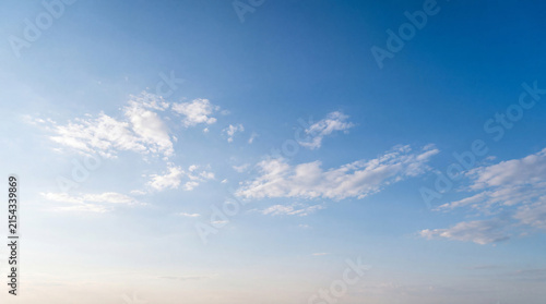 Fotografía Clear blue sky with small, delicate white clouds scattered across a serene, expansive backdrop
