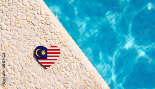 Malaysia flag in the shape of a heart near the pool in the hotel. Holiday concept in hotels