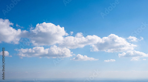 Quadro su tela Vibrant blue sky with scattered fluffy white cumulus clouds, forming a serene and expansive natural backdrop