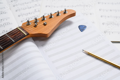 Musical creativity. Music notebook, pencil, and guitar. Selective focus, white space.