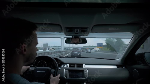 Interior driver view inside modern car with hands on wheel during highway drive