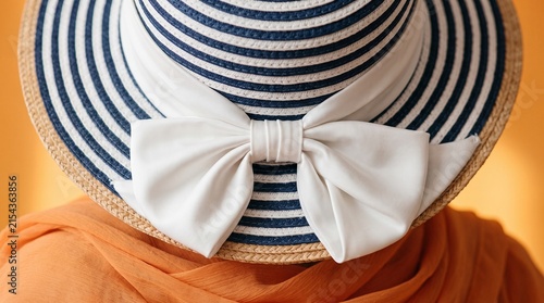 Close up of woman wearing striped sun hat with white bow on back.