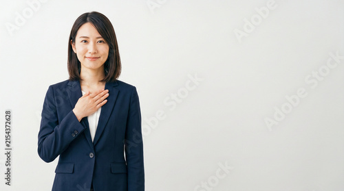 Naklejka 胸に手を当て微笑むビジネスウーマン