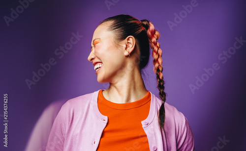 Laughing woman with braided hair brings joyful energy to the studio portrait