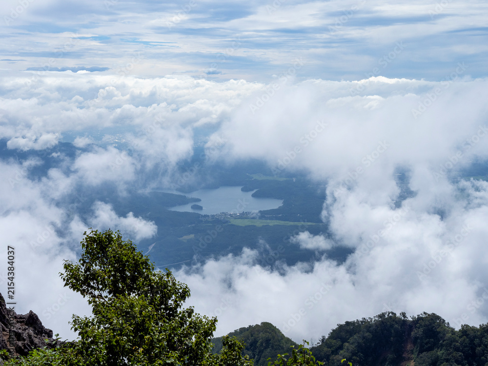 Fototapeta premium Mountain Lake Revealed Through Drifting Clouds from a High Alpine Viewpoint