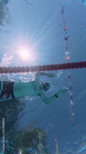 Low Angle Underwater View of Man Swimming with Fins in Pool