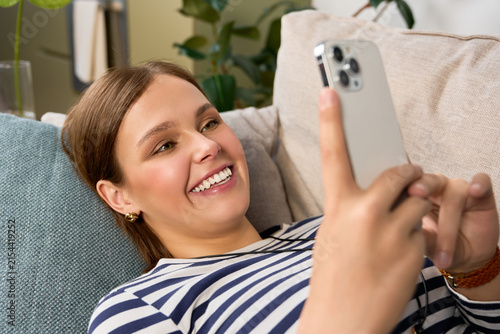 Photography Cozy moments with a beautiful young woman enjoying her phone in a relaxed settin