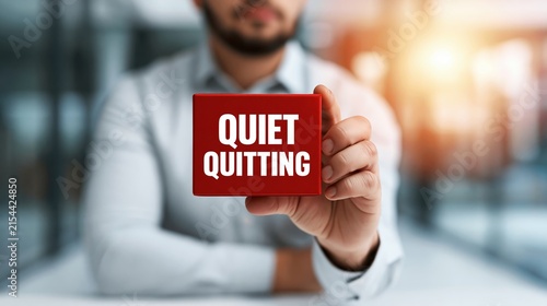 Person holding red block with quiet quitting text, illustrating new workplace trend and employee disengagement