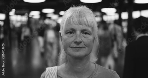 Caucasian senior woman looking at camera at subway - Urban lifestyle and travel concept - Black and white editing - UGC content - Main focus on face