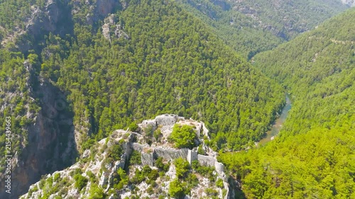 Cakallar, Alanya, Turkey. Alara Castle, ancient stone fortress ruins crowning a rocky hilltop, aerial drone view over the Alara River valley under bright summer sun. Aerial View, MasterShots, Spiral 