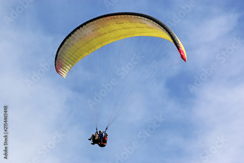 Tandem Paraglider flying in a blue sky	