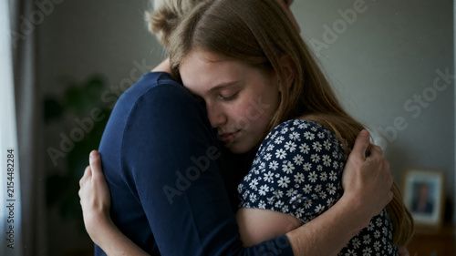 Girl hugs someone close, eyes closed in comfort