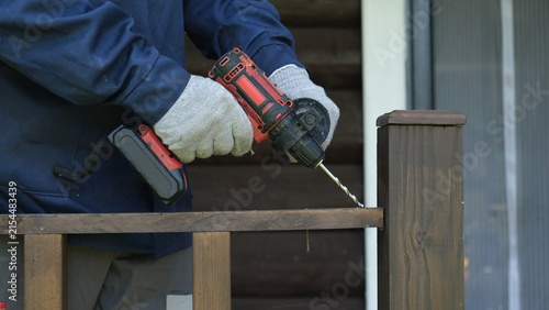 Canvastavla Builder worker using cordless hammer drill