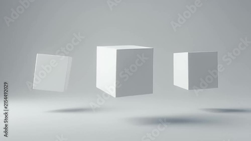 White cubes float in a minimalist grey studio space with soft shadows, creating a clean geometric composition suitable for abstract backgrounds and modern design concepts.