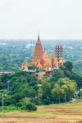 Landscape of Wat Tham Sua Temple (Tiger Cave Temple) in Sunset scence with Jasmine rice fields at Kanchanaburi Province, Thailand. Is an important landmark that everyone must visit