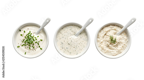 Three bowls of white creamy dips with herbs for food styling.