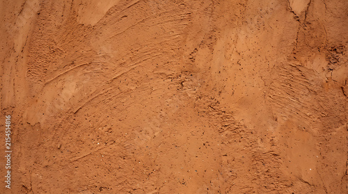 Terracotta plaster wall texture with stucco finish, orange rough surface background, rustic brown relief pattern for design