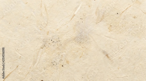 Closeup texture of handmade beige paper with natural fibers and subtle imperfections