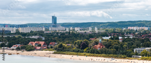 Bild auf Leinwand An elevated perspective shows the coastal town of Sopot in Poland with people relaxing on the sandy beach, historic buildings, and modern skyscrapers