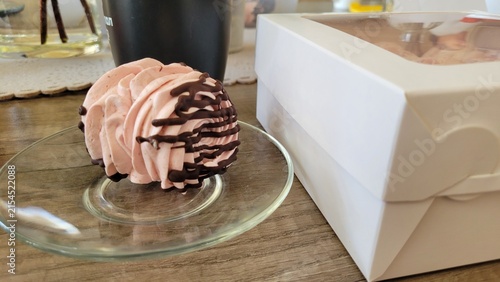 Pink marshmallow dessert with chocolate drizzle served on glass plate