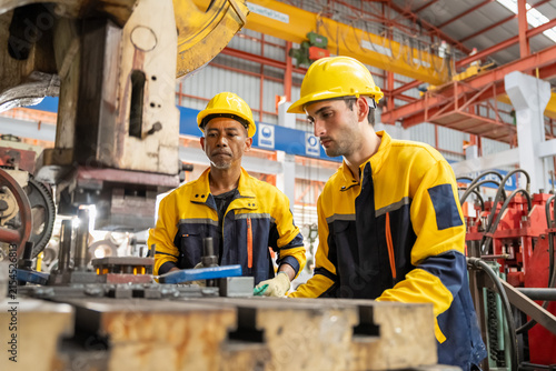 Two experienced professionals working together on a manufacturing project in a workshop environment
