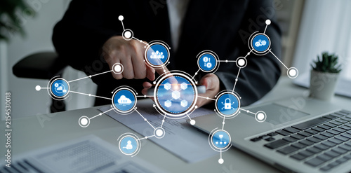 Fotografie A businessman interacts with a smartphone in a modern office, accessing a digital network of communication and data sharing