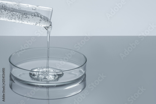 Clear Cosmetic Gel Pouring from Test Tube into Glass Petri Dish