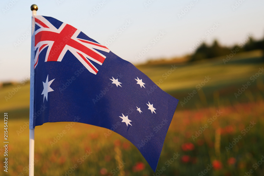 Obraz premium Australian flag waving against sunset field sky