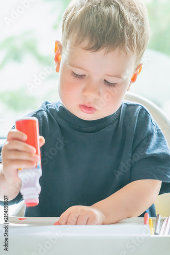 Natural unposed photo of a toddler developing creativity through an artistic activity.