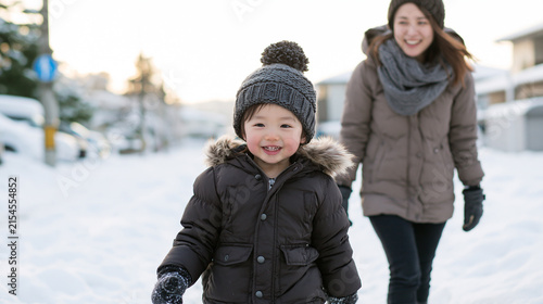 Obraz na płótnie 雪道を歩く笑顔の男の子と母親