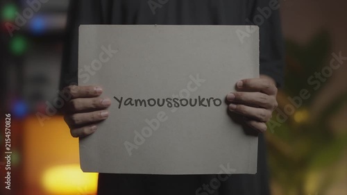 Yamoussoukro written on Banner – Man Holding Placard