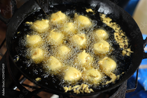 Indian style vada being deep-fried in hot oil, a traditional savory snack commonly enjoyed as street food and breakfast in India.