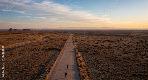 Long straight road stretching across a vast desert landscape.