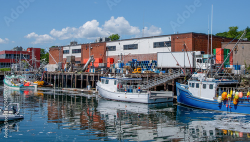 Fotografie Commercial Fishing Dock in Massachusetts:  Fishing boats unload the day’s catch while a transport truck waits on a dock in Gloucester, MA