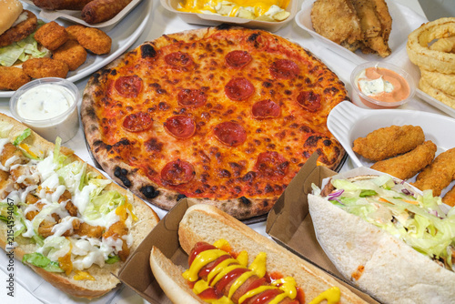 Pepperoni pizza with assorted takeaway food, fried chicken, hot dog and kebab