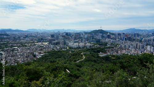 Panoramic aerial view of Seoul cityscape featuring N Seoul Tower, downtown skyline, and lush green mountains, South Korea

